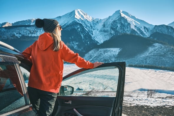 Dame med ny bil i fjellandskap